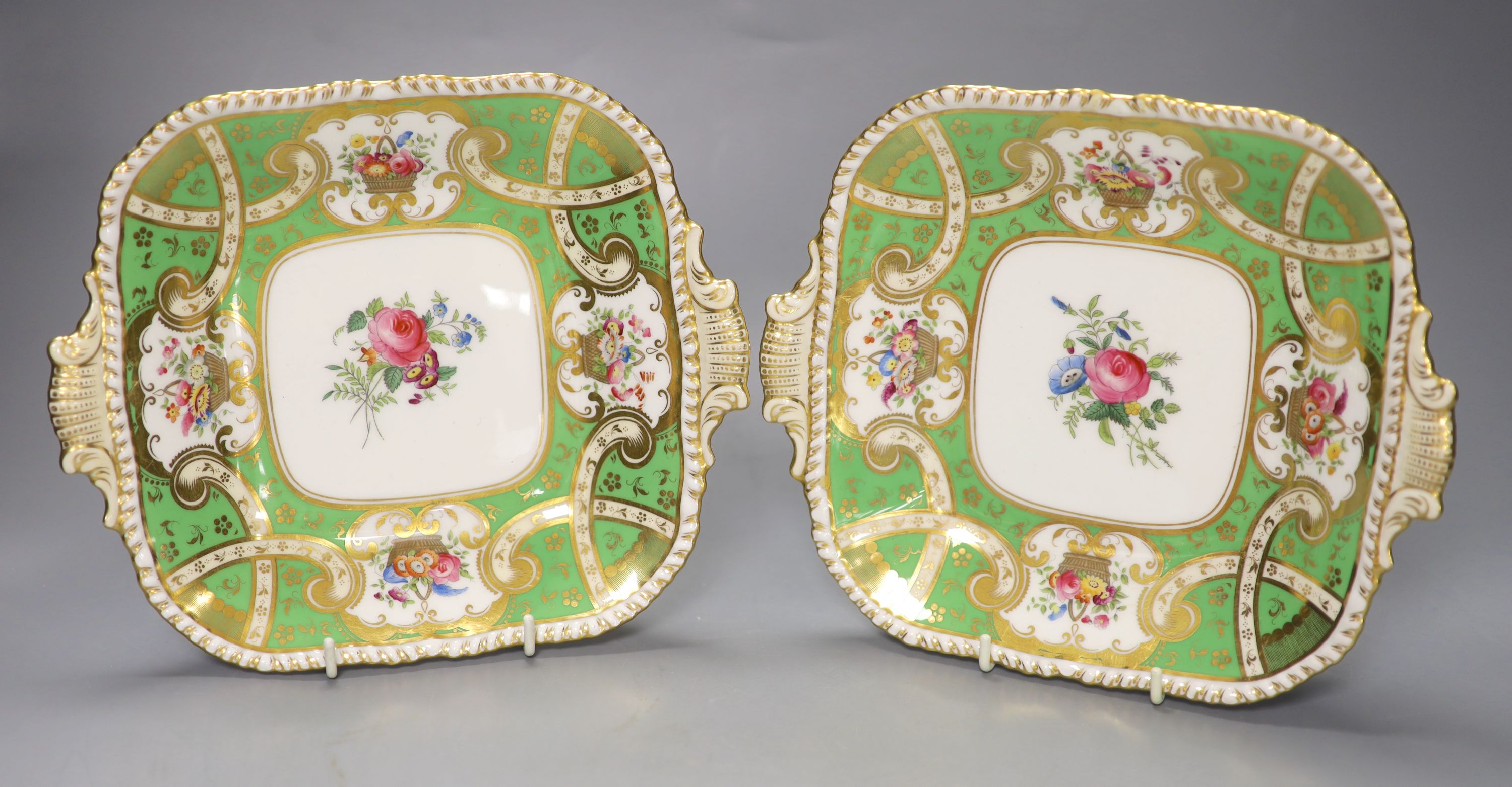 A pair of early 20th century Coalport square dishes. painted with a central spray of flowers and four gilt floral panels on a wide gree